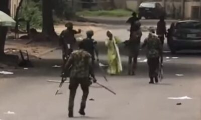 A photo shows Nigerian Army Guards Brigade officers arresting and beating a teenage girl during the protest.